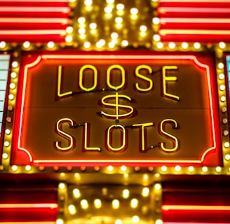 Bright neon lights display the words 'Loose Slots' with a dollar sign in the center. The sign is outlined with bulbs, creating a vibrant and flashy effect typical of a casino or entertainment venue.